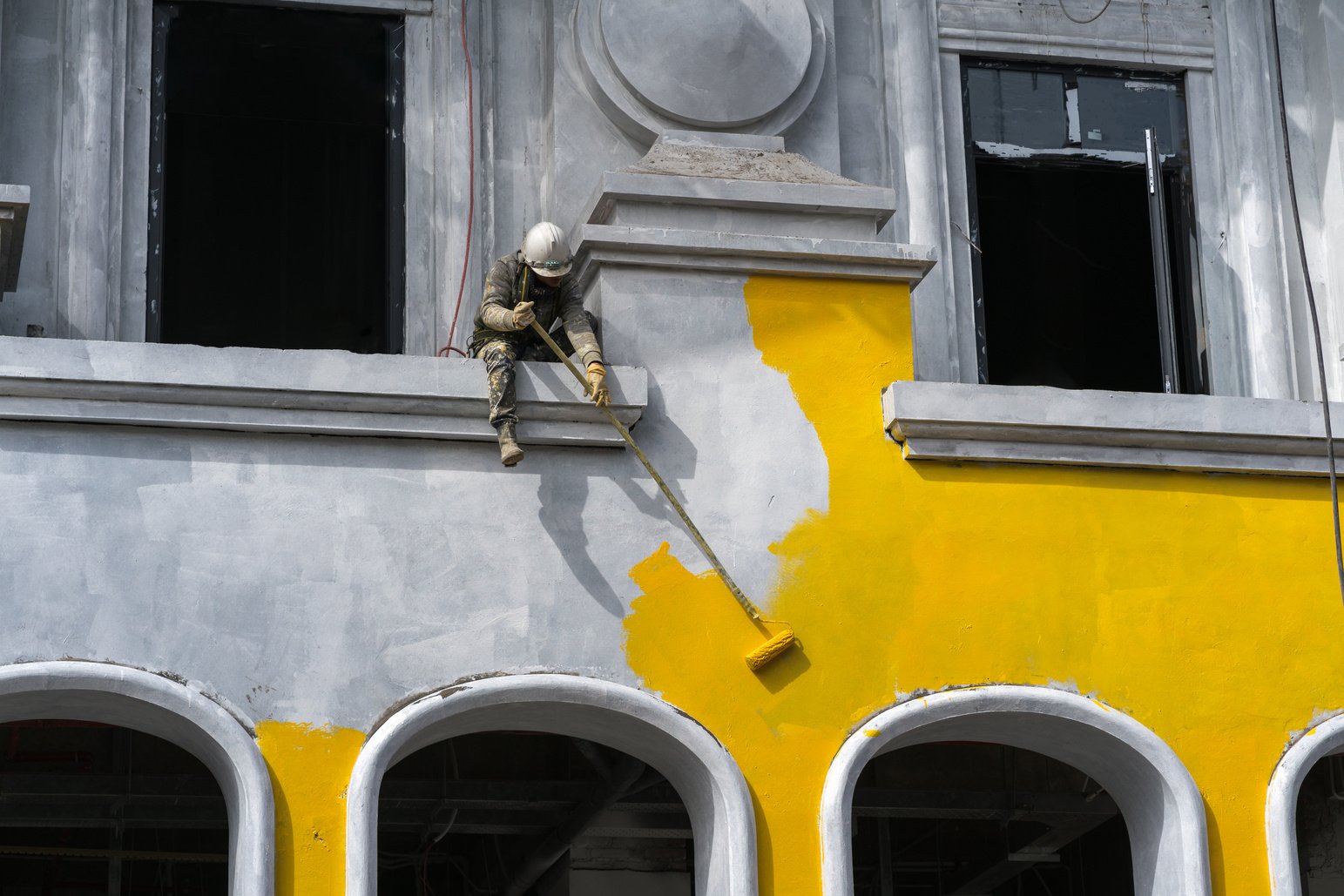 Worker Painting Exterior of a Building 